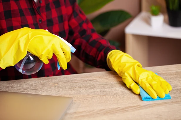 Professional cleaner entering room with cleaning supplies